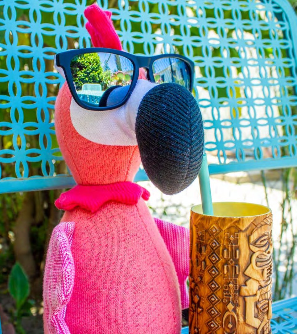 Carl the Flamingo wearing goodr sunglasses with a tiki drink